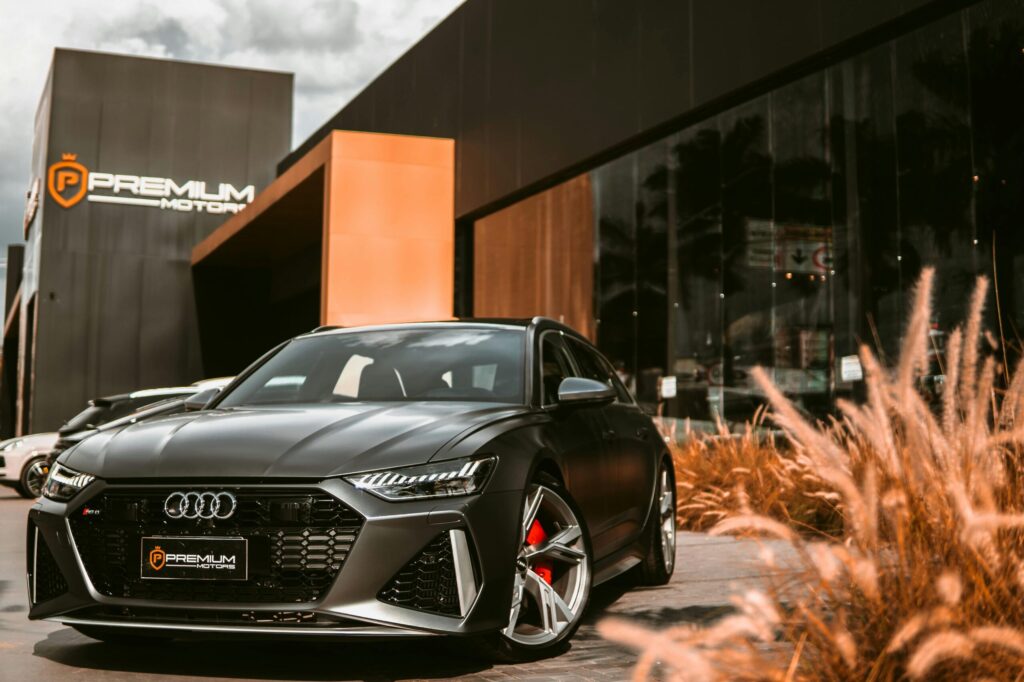Sleek black luxury sports car parked in front of a modern showroom at Premium Motors.